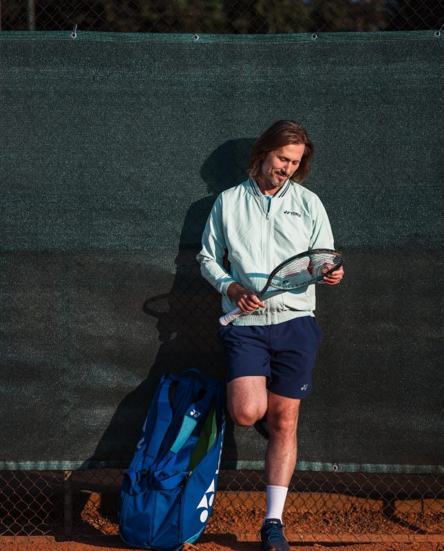 Nick Horvat looking at tennis racket