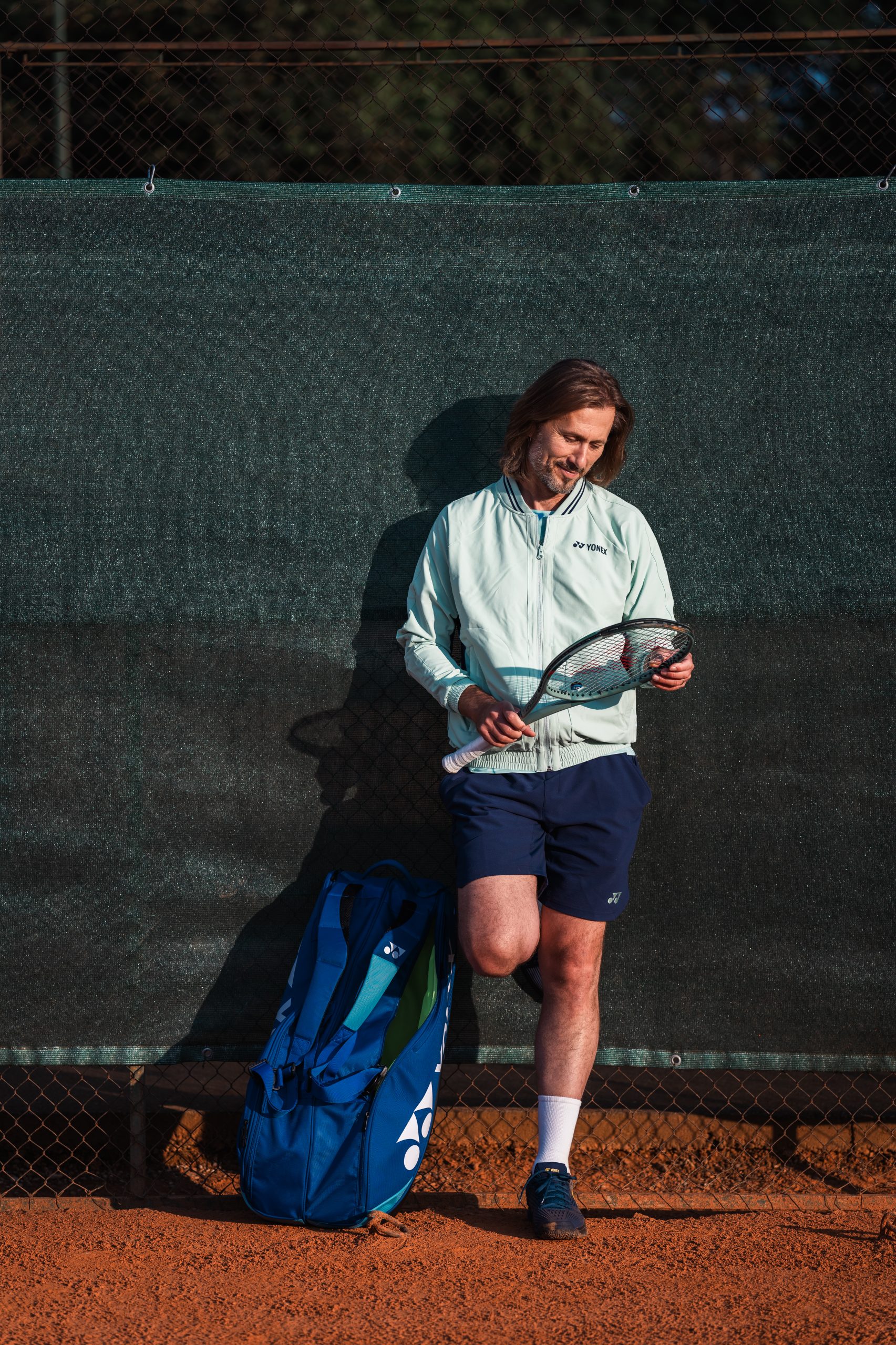 Nick Horvat looking at tennis racket
